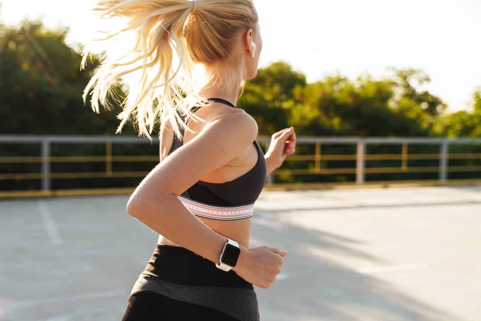 Runner wearing a smartwatch jogging outdoors near The 208 in Boise, ID